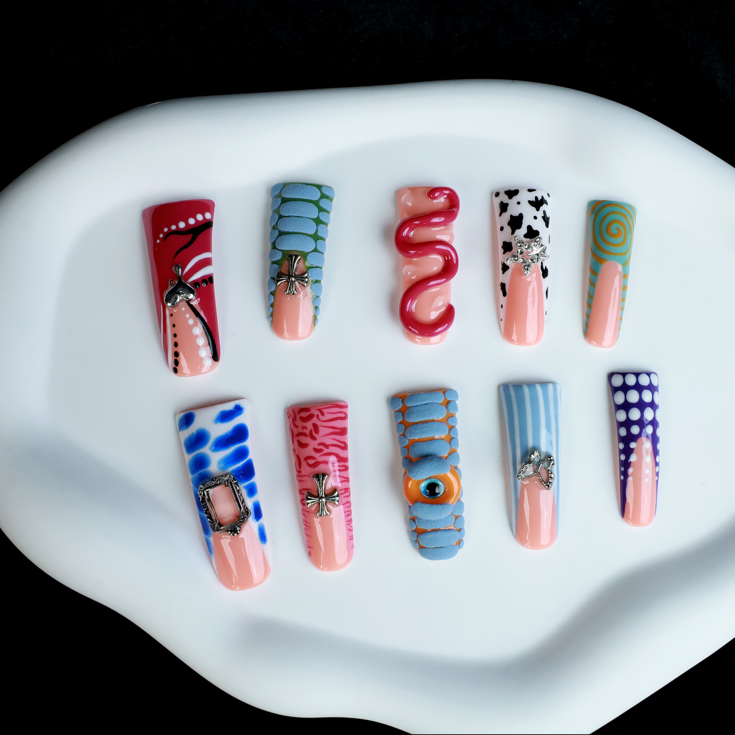 Two hands showcase the Avant-Garde 3D Extra Long Duck Nails by We Do Nails, featuring blue textures, cow print, pink patterns, and colorful designs against a black background. Ship Next Day text highlights custom size and nail measurement personalization options.