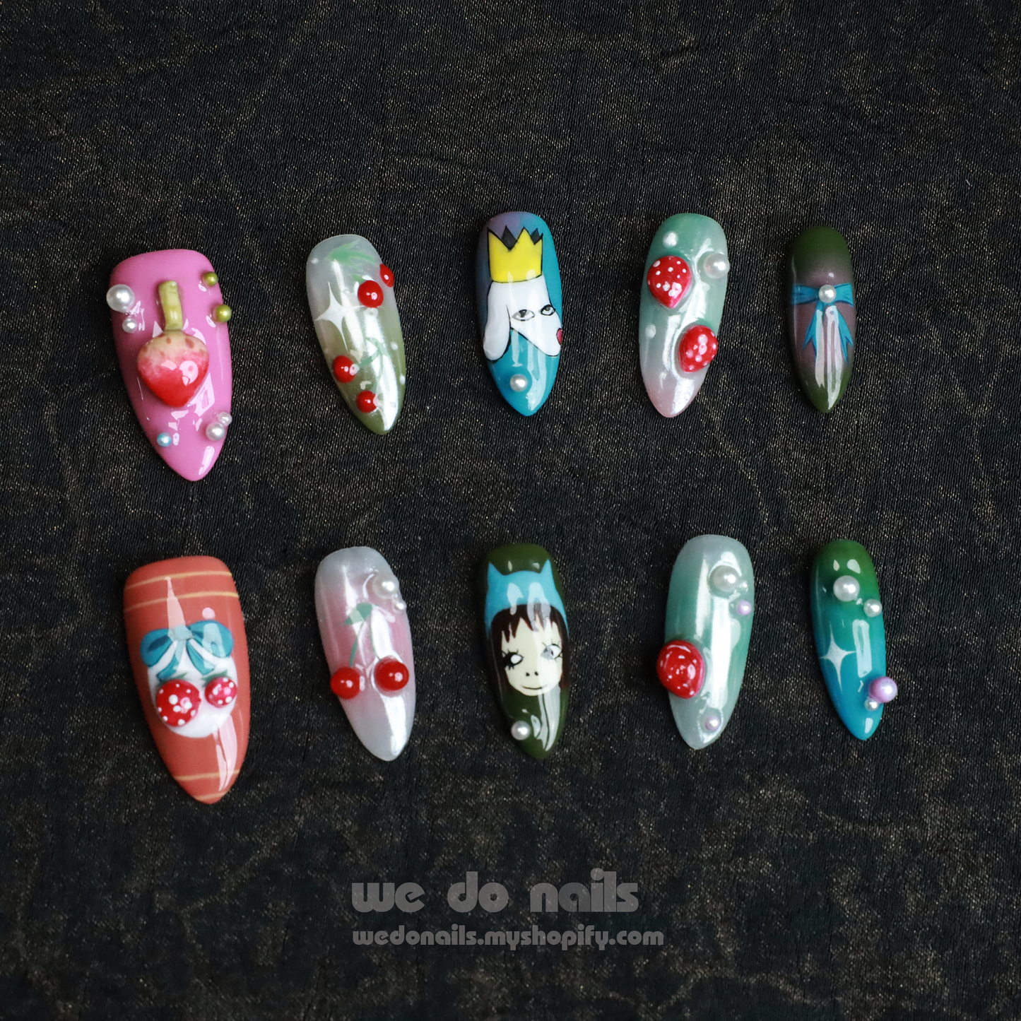 Someone with long, intricately painted 3D cartoon Blossom Bliss Press-On Nails by We Do Nails holds a black mug against a dark background. In the top left corner, a pink box reads SHIP NEXT DAY.