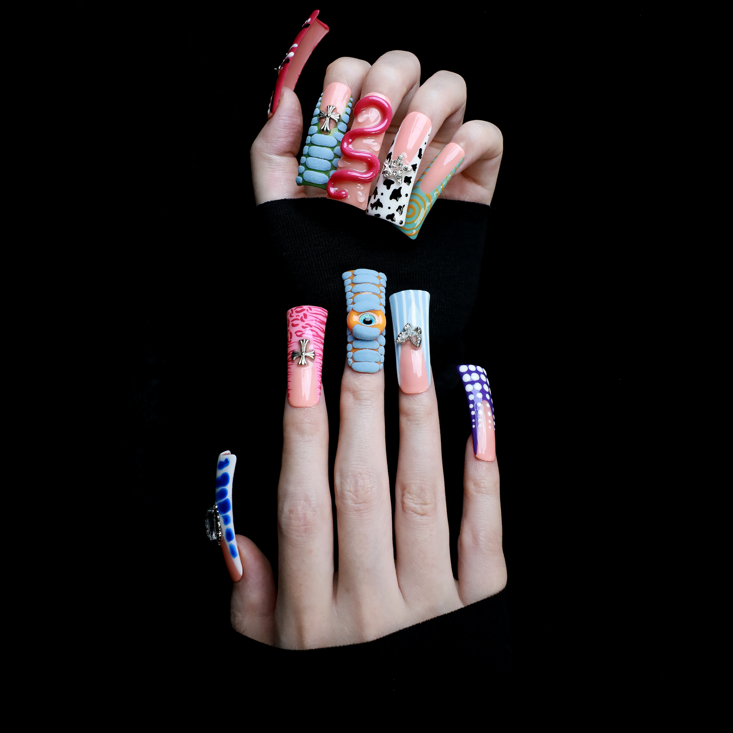 Two hands showcase the Avant-Garde 3D Extra Long Duck Nails by We Do Nails, featuring blue textures, cow print, pink patterns, and colorful designs against a black background. Ship Next Day text highlights custom size and nail measurement personalization options.