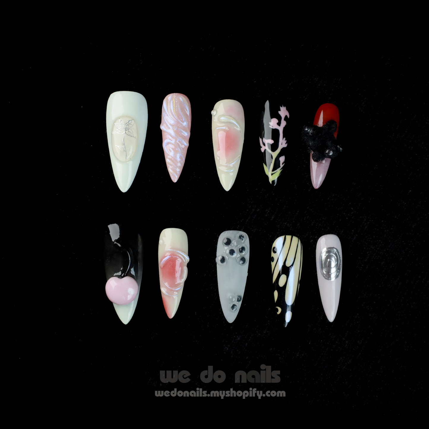 A hand holds a white mug, displaying We Do Nails Abstract Floral Design Press-On Nails, featuring intricate floral patterns in vibrant colors against a dark backdrop. Text: We Do Nails wedonails.myshopify.com.