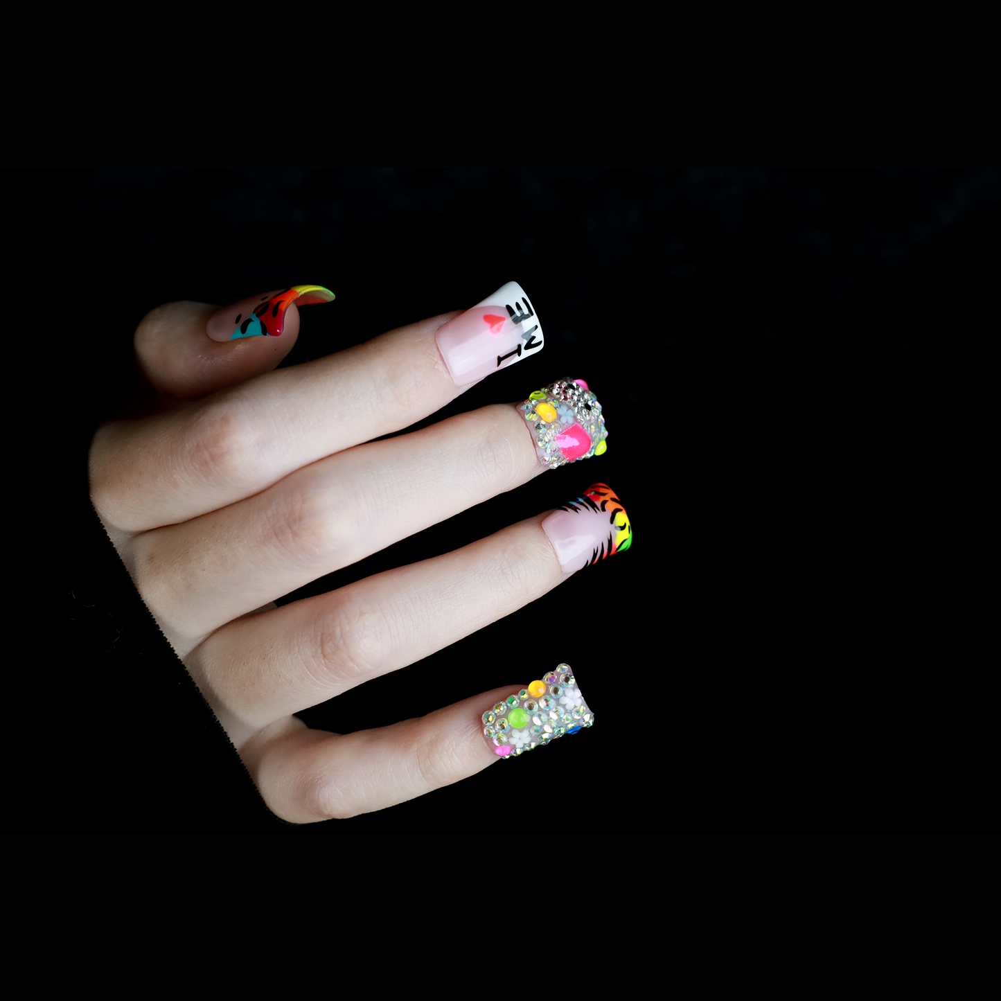 A pair of hands showcases long, decorated nails with Y2K-inspired art, including hearts and lettering. A pink banner reads SHIP NEXT DAY. The black backdrop highlights the vibrant leopard and tiger print accents on these striking Neon Safari Short Duck Press-On Nails by We Do Nails.