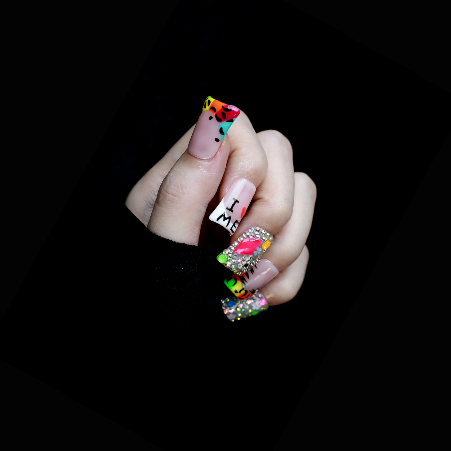 A pair of hands showcases long, decorated nails with Y2K-inspired art, including hearts and lettering. A pink banner reads SHIP NEXT DAY. The black backdrop highlights the vibrant leopard and tiger print accents on these striking Neon Safari Short Duck Press-On Nails by We Do Nails.
