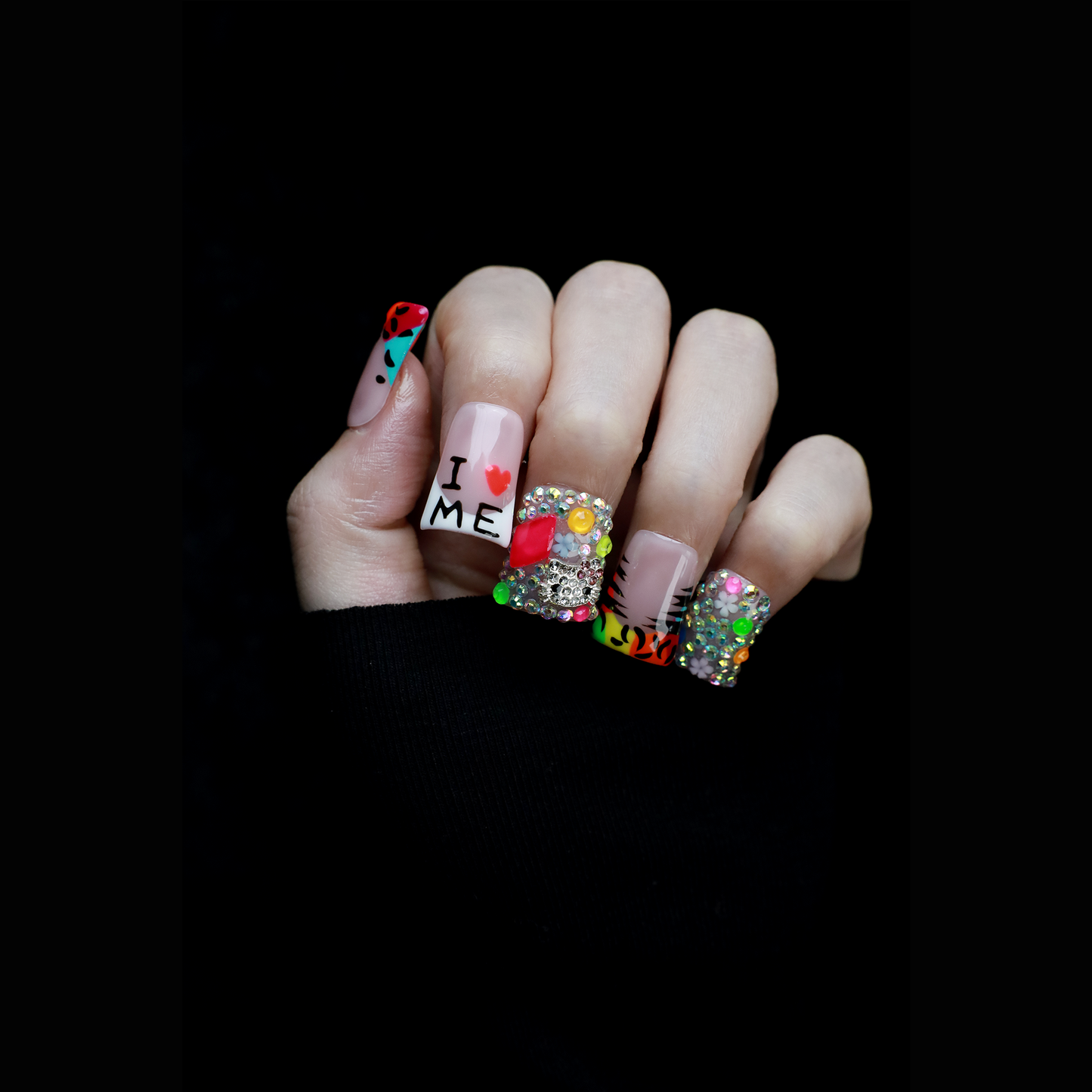A pair of hands showcases long, decorated nails with Y2K-inspired art, including hearts and lettering. A pink banner reads SHIP NEXT DAY. The black backdrop highlights the vibrant leopard and tiger print accents on these striking Neon Safari Short Duck Press-On Nails by We Do Nails.