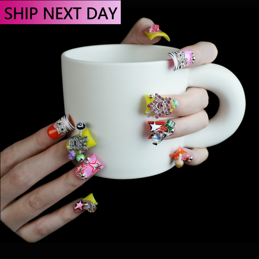 A hand with intricately decorated Neon Pop Star Short Duck Press-On Nails by We Do Nails clutches a large white mug. The duck-shaped neon nails showcase various designs, gems, and tiny figures. A pink banner in the top left corner reads SHIP NEXT DAY.