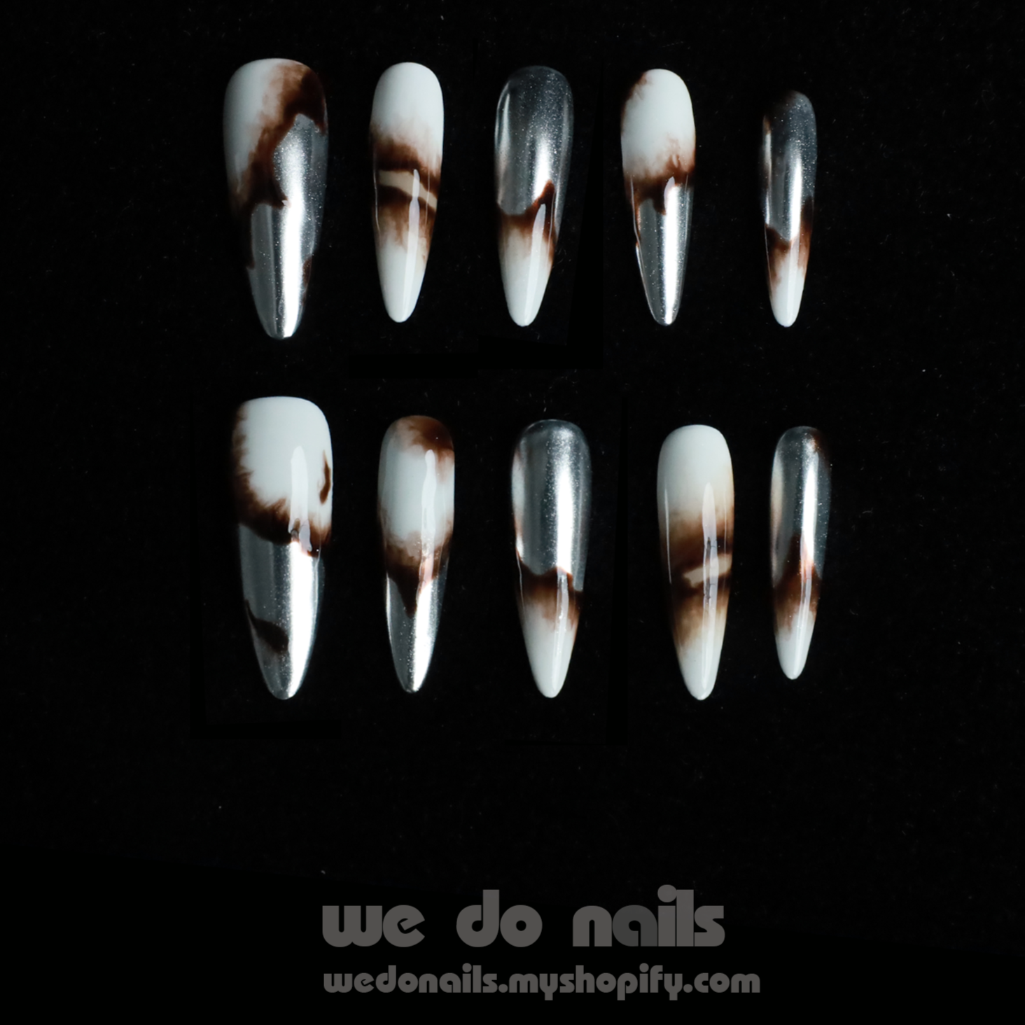 A pair of hands showcases Sizzling Marble Press-On Nails with a black and white marbled design, paired with a black long-sleeved sweater. Text includes We Do Nails and a URL. Stylish nails that redefine elegance!.