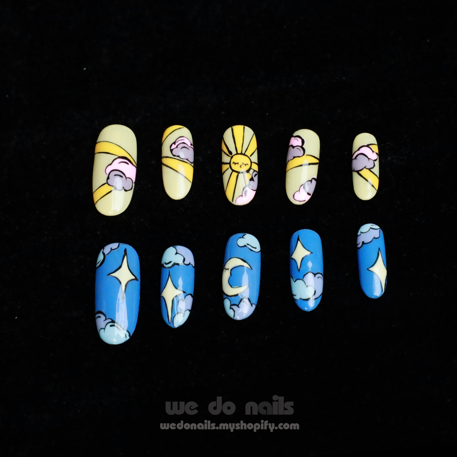 Close-up of hands showcasing artistic nail designs from We Do Nails. One set, Sunrise, features yellow nails with flowers and the other, Moonlight, displays blue nails with cloud patterns. The person is in a black sweater with a logo visible at the bottom left.