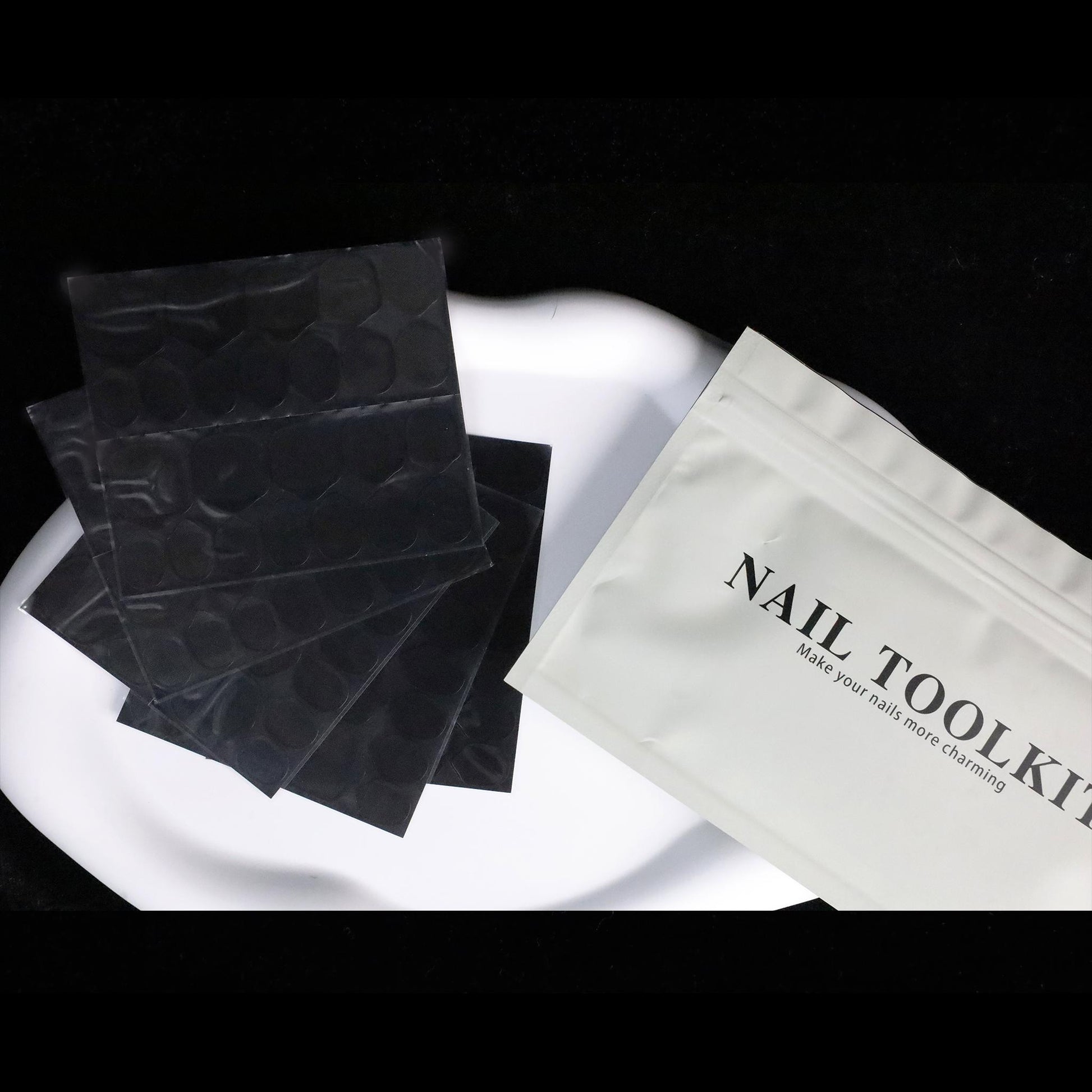 Two sheets of WeDoNails Best Nail Glue For Press On Nails with a pebble pattern sit on a round wooden platform. The text reads The Future of Nail Adhesive, emphasizing its safety, innovation, ease, and durability for nail applications. A soft, bright background enhances this cutting-edge product.