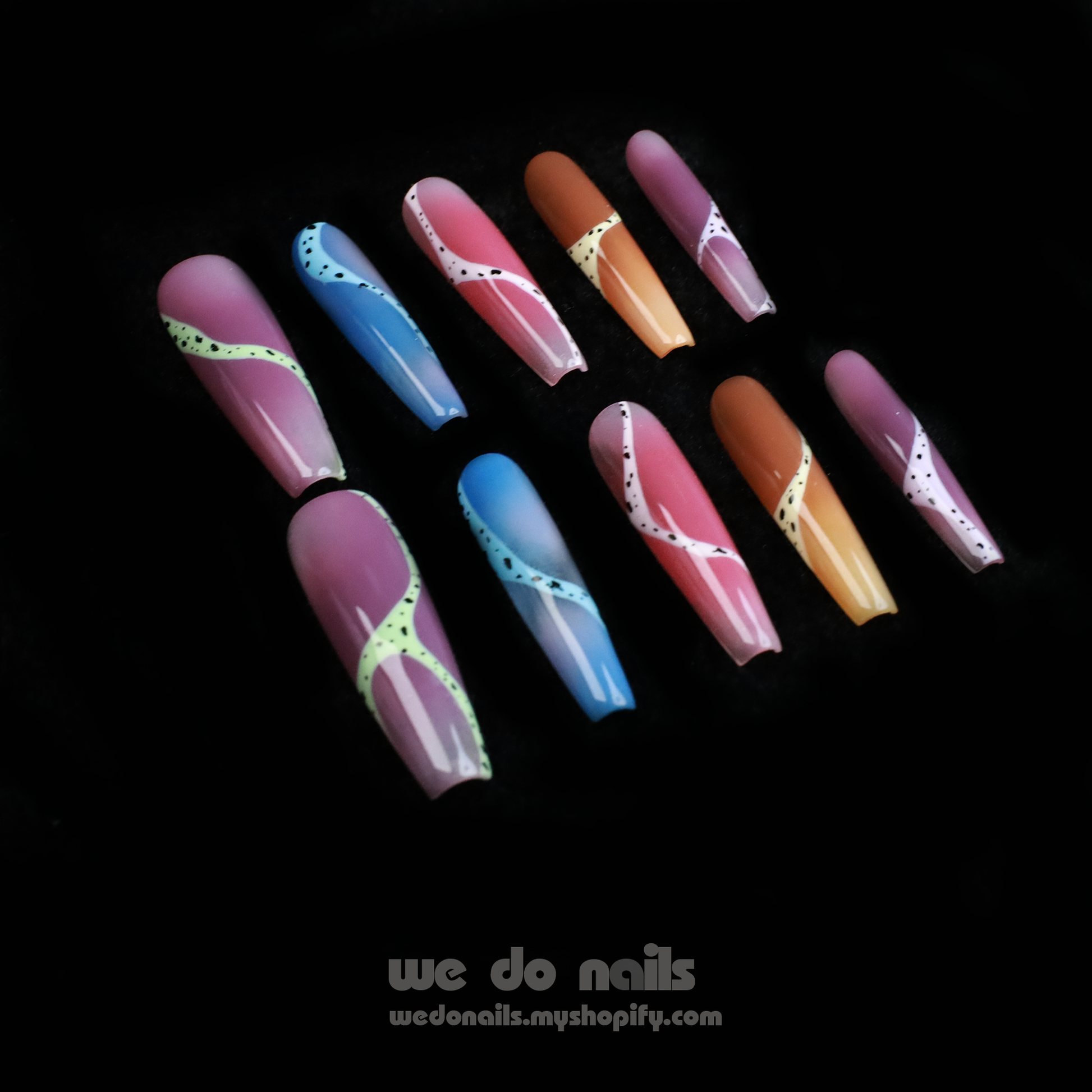 A hand adorned with Milky Rainbow Press-On Nails exhibits a smooth gradient and dotted 3D designs against a black background. The text We Do Nails appears alongside the website link, emphasizing the brands artistry.