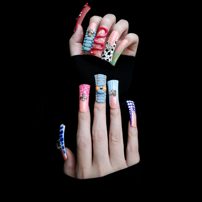 Two hands showcase the Avant-Garde 3D Extra Long Duck Nails by We Do Nails, featuring blue textures, cow print, pink patterns, and colorful designs against a black background. Ship Next Day text highlights custom size and nail measurement personalization options.