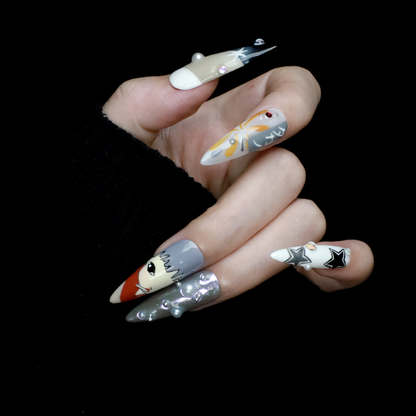 A hand with long, pointed Japanese-Inspired Artistic Press-On Nails by We Do Nails showcases camo patterns in green, red, and gray. Combining kawaii aesthetic and artistic motifs that suggest anime nail art, the hand is partially covered by a black sleeve.