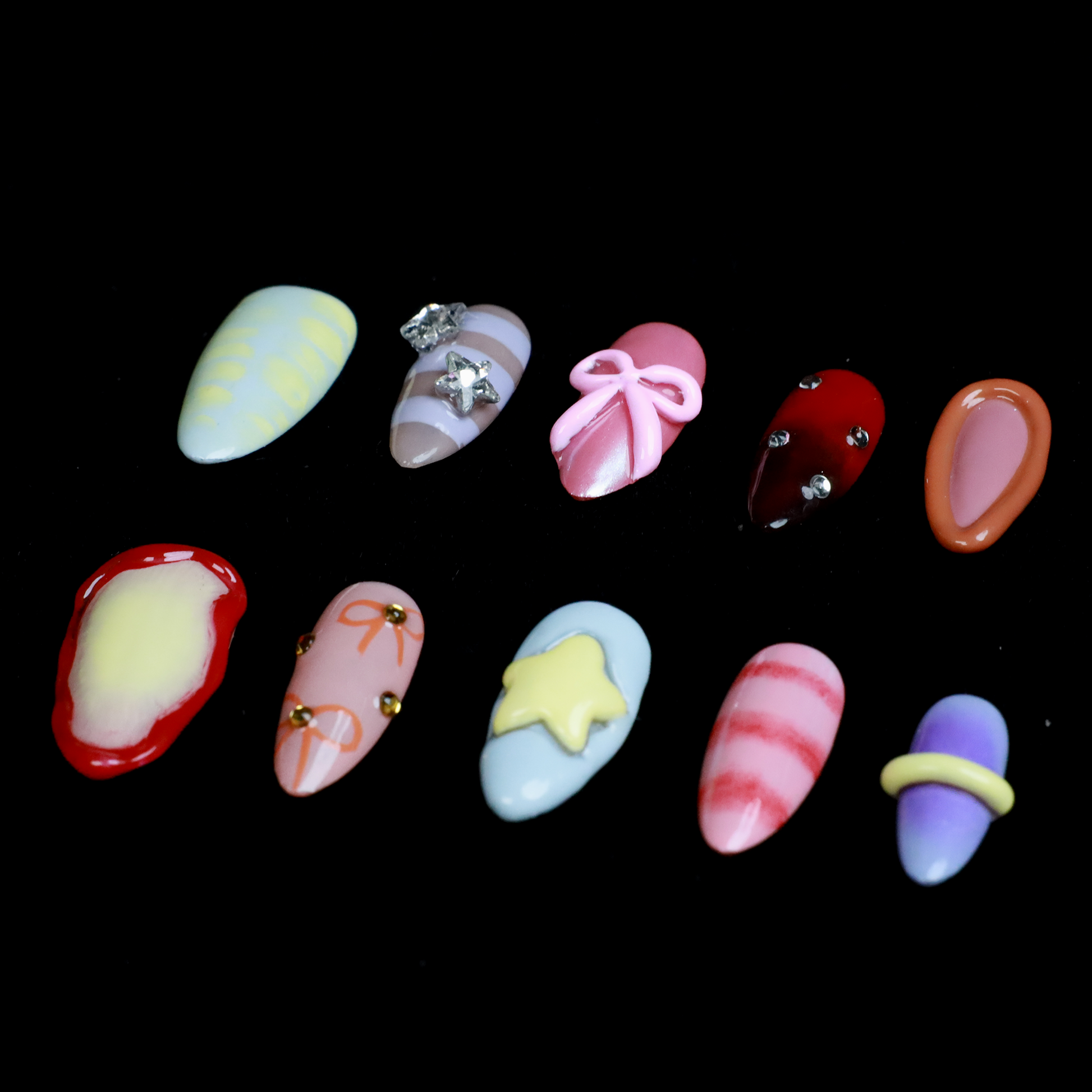 A hand with We Do Nails Candyland Dream Press-On Nails displays playful designs. Features include pastel yellow plaid, clear nails with bows and rhinestones, pink nails with a bow, shiny red with rhinestones, and glossy rust-orange—all set against a dark backdrop.