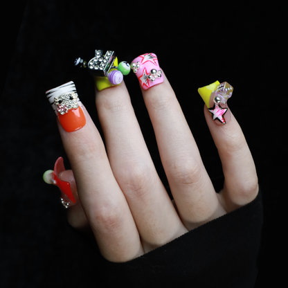 A hand with intricately decorated Neon Pop Star Short Duck Press-On Nails by We Do Nails clutches a large white mug. The duck-shaped neon nails showcase various designs, gems, and tiny figures. A pink banner in the top left corner reads SHIP NEXT DAY.