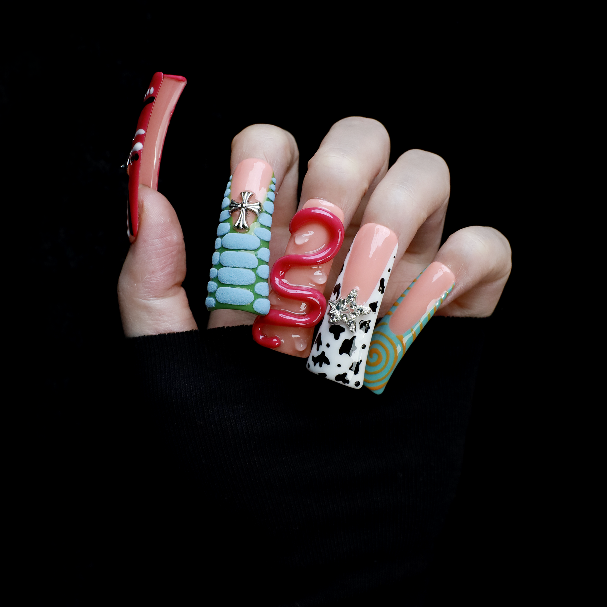 Two hands showcase the Avant-Garde 3D Extra Long Duck Nails by We Do Nails, featuring blue textures, cow print, pink patterns, and colorful designs against a black background. Ship Next Day text highlights custom size and nail measurement personalization options.